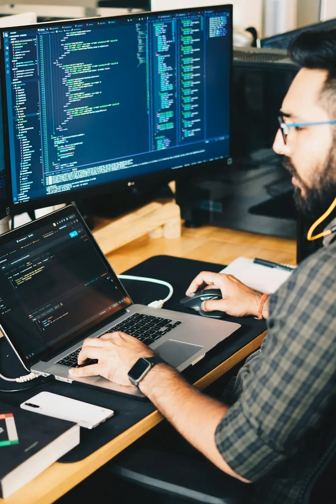 IT consultant coding at two screens